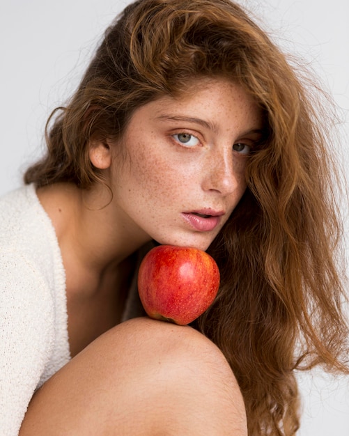 Mujer bonita posando con manzana roja