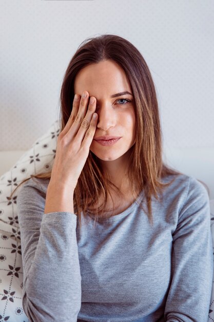 Mujer bonita que cubre el ojo