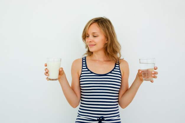 Mujer bonita que elige entre el agua y la leche