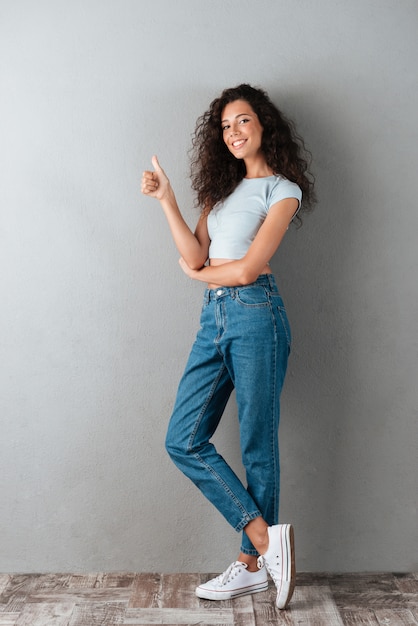 Mujer bonita que muestra el pulgar arriba gesto aislado