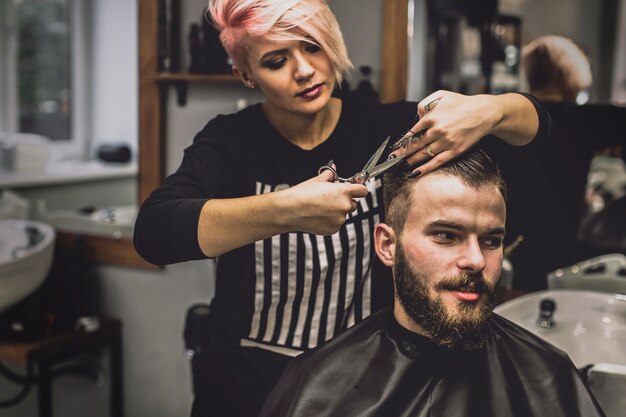 Mujer bonita que prepara el pelo del hombre