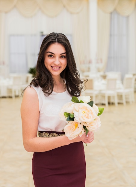 Mujer bonita con ramo de flores en las manos