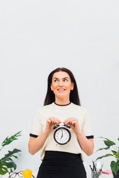 Mujer bonita con reloj en manos sonriendo