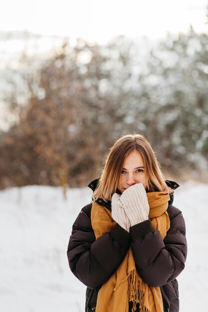 Mujer bonita en ropa de invierno calentando las manos