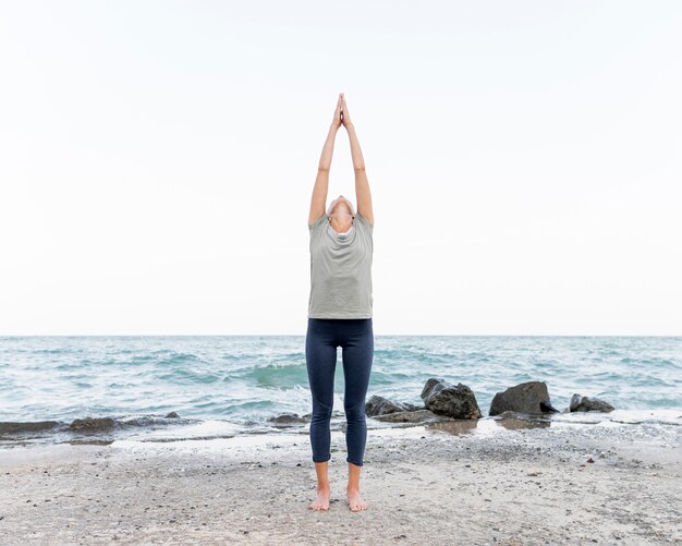 Mujer bonita rubia practicando yoga al aire libre