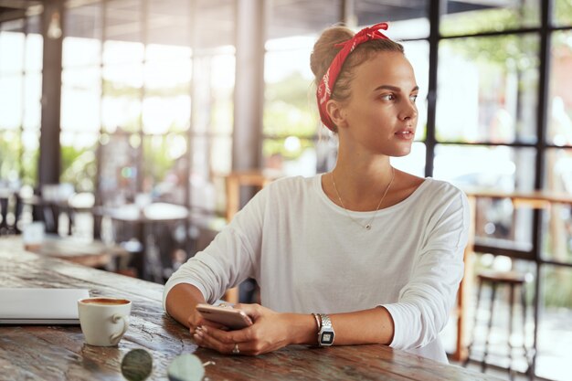 Mujer bonita rubia sentada en el café