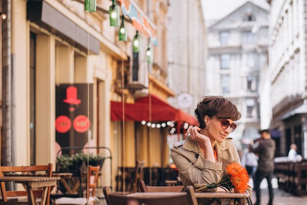 Mujer bonita sentada en un café en la ciudad de China