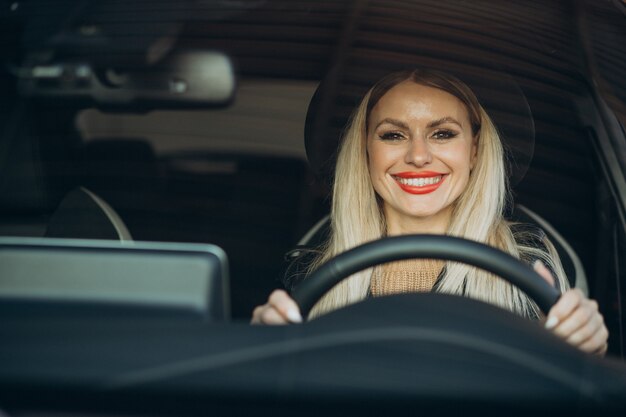 Mujer bonita sentada en su coche