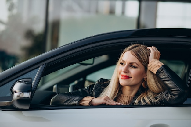 Mujer bonita sentada en su coche