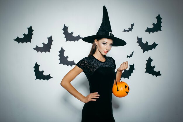 Mujer bonita en sombrero con calabaza