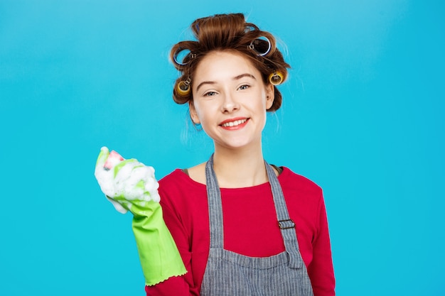 Mujer bonita sonriente en traje rosa con guantes verdes