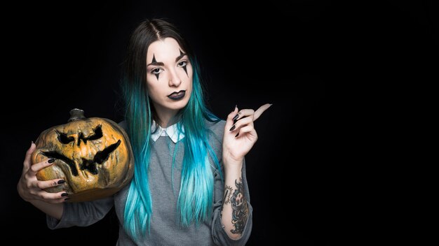 Mujer bonita con tenebrosa Jack-O-Lantern