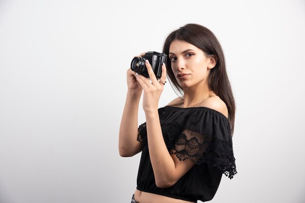 Mujer bonita tomando fotos con una cámara