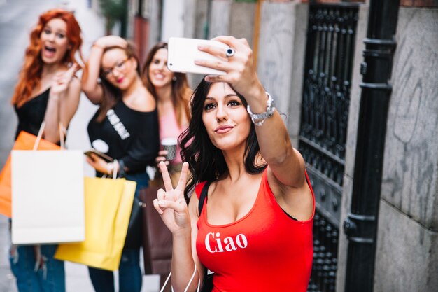 Mujer bonita tomando selfies con sus amigos