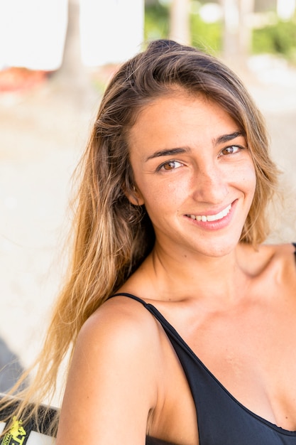 Mujer bonita en traje de baño negro sonriendo