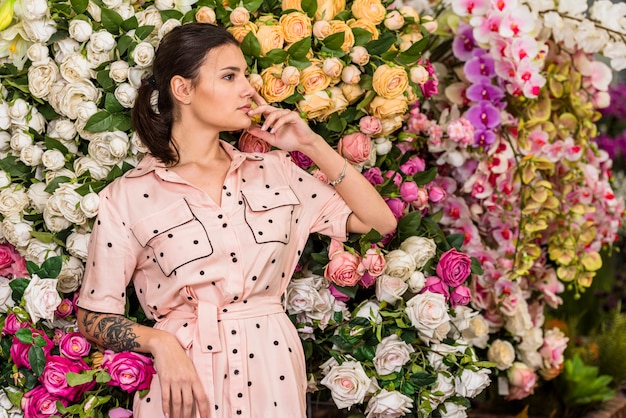 Foto gratuita mujer bonita en el vestido que se coloca en casa verde