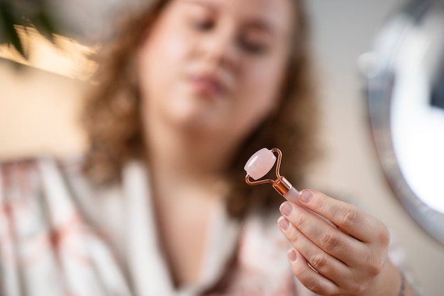 Mujer borrosa con herramienta gua sha