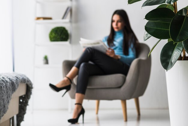 Mujer borrosa leyendo periódico