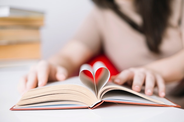 Mujer borrosa con libro con corazón