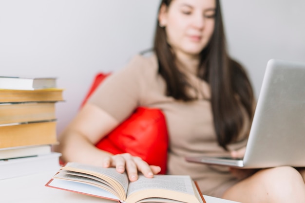 Foto gratuita mujer borrosa con libro de lectura portátil