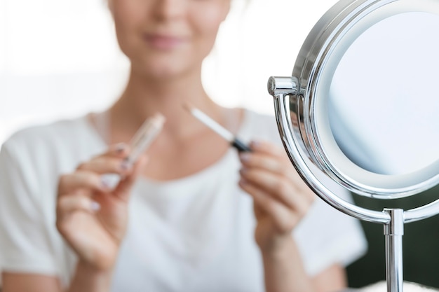 Mujer borrosa con maquillaje y espejo