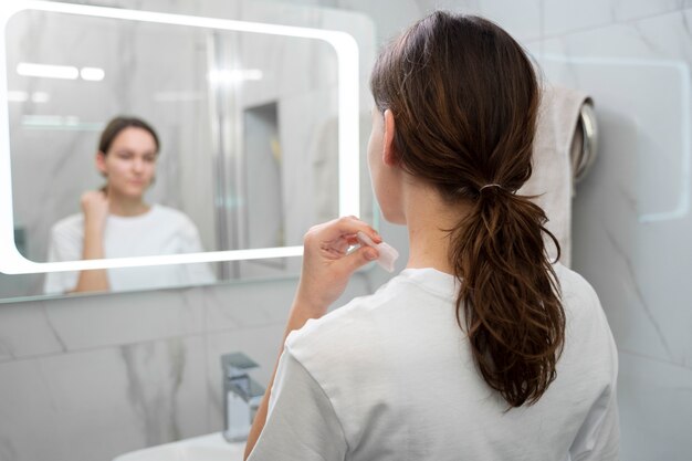 Mujer borrosa de tiro medio usando la herramienta gua sha