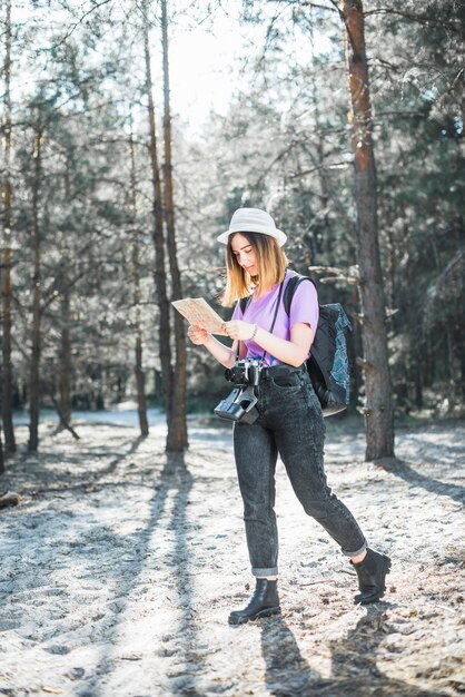 Mujer en el bosque leyendo mapa