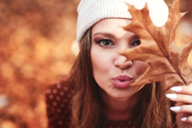 Foto gratuita mujer en bosque otoñal que fluye un beso