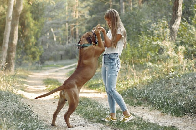 mujer en un bosque de verano jugando con perro