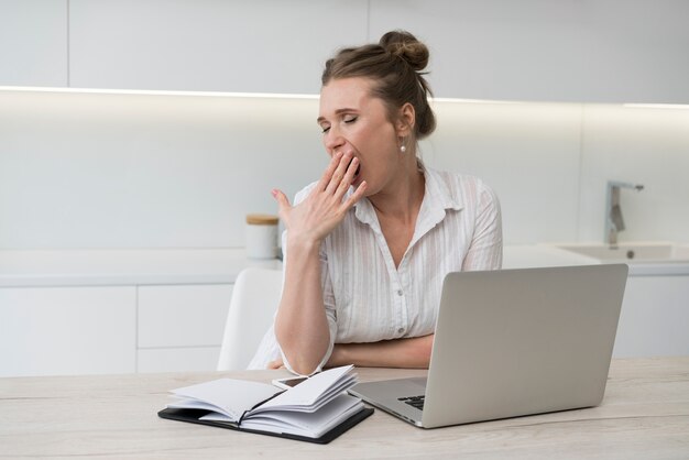 Mujer bostezando en el escritorio