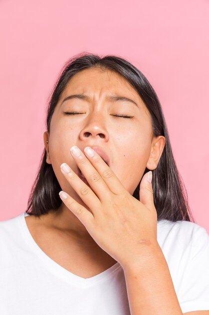 Mujer bostezando con los ojos cerrados