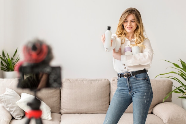 Foto gratuita mujer con botellas grabando a sí misma