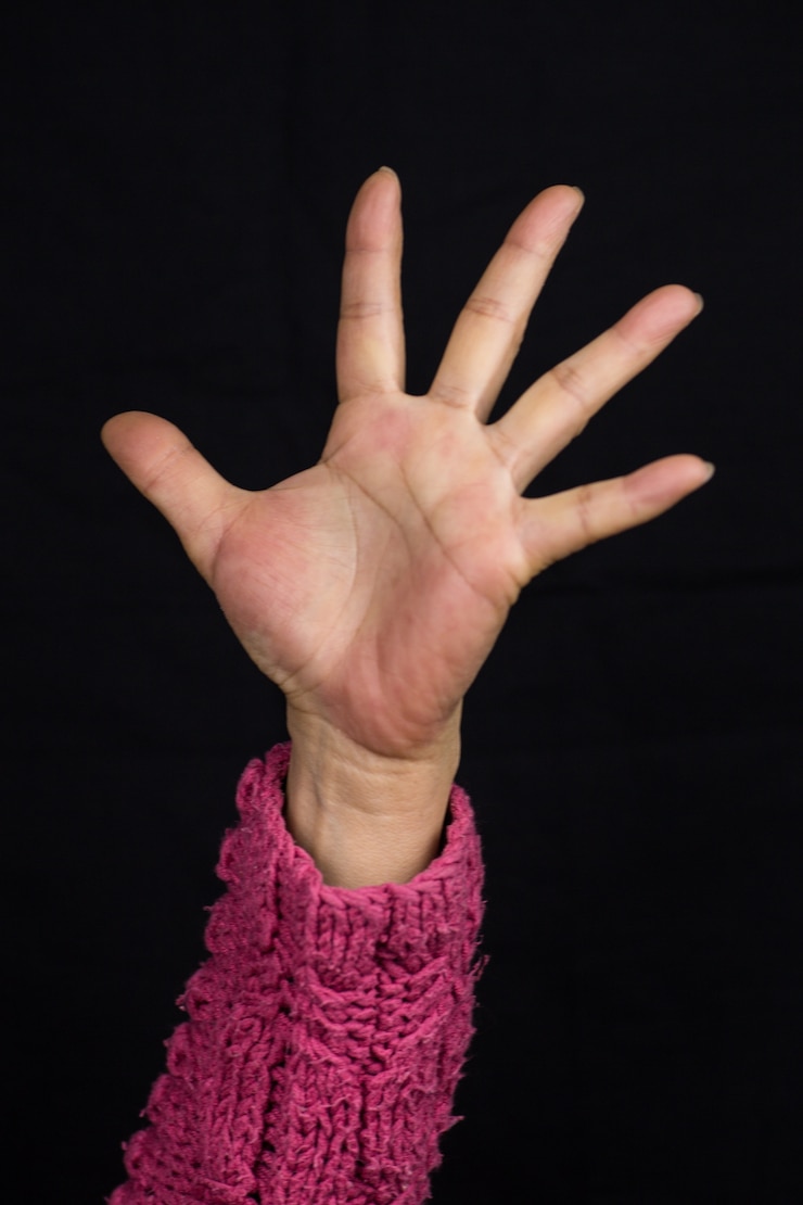 Foto gratuito mujer con brazo estirado en un suéter rosa
