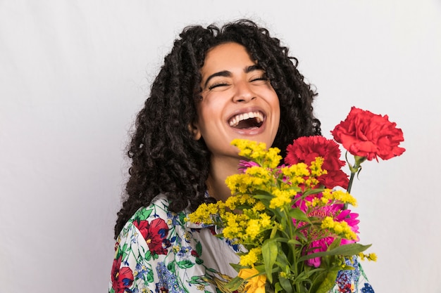 Mujer brillante riendo con ramo de flores
