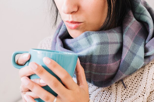 Mujer, en, bufanda, soplar, en, taza