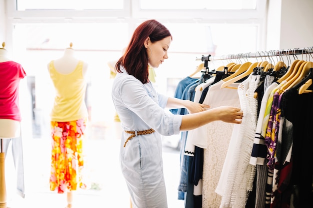 Foto gratuita mujer en busca de ropa nueva