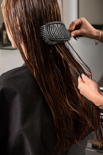 Mujer con cabello cepillado en peluquería latina