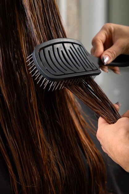 Mujer con cabello cepillado en peluquería latina