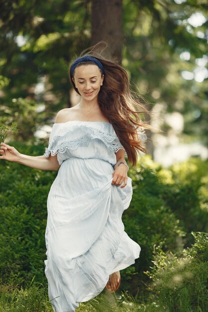 Mujer con cabello largo. Dama con un vestido azul. Chica con naturaleza virgen.