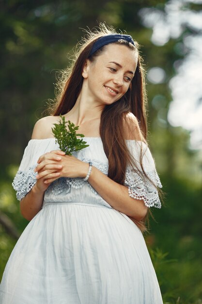 Mujer con cabello largo. Dama con un vestido azul. Chica con naturaleza virgen.