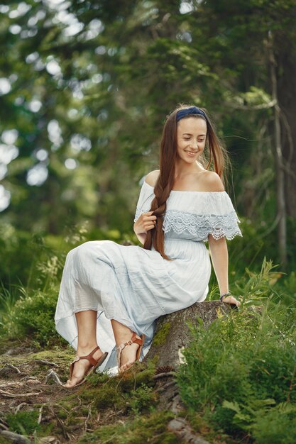 Mujer con cabello largo. Dama con un vestido azul. Chica con naturaleza virgen.