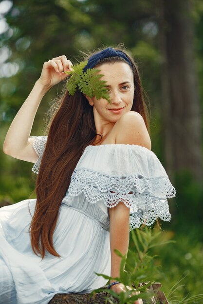 Mujer con cabello largo. Dama con un vestido azul. Chica con naturaleza virgen.