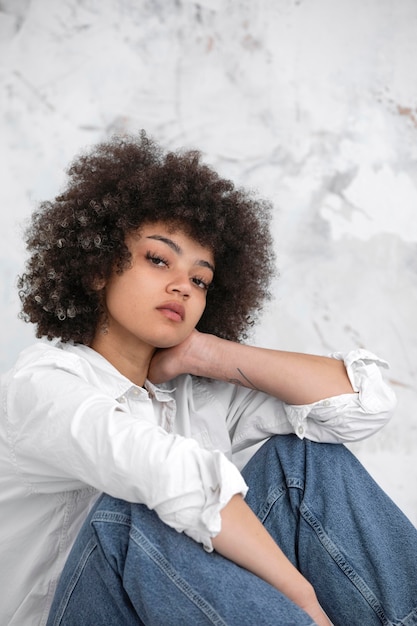 Mujer con cabello rizado posando de manera segura