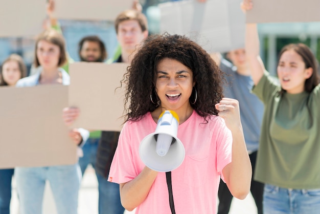 Mujer con cabello rizado protestando con megáfono