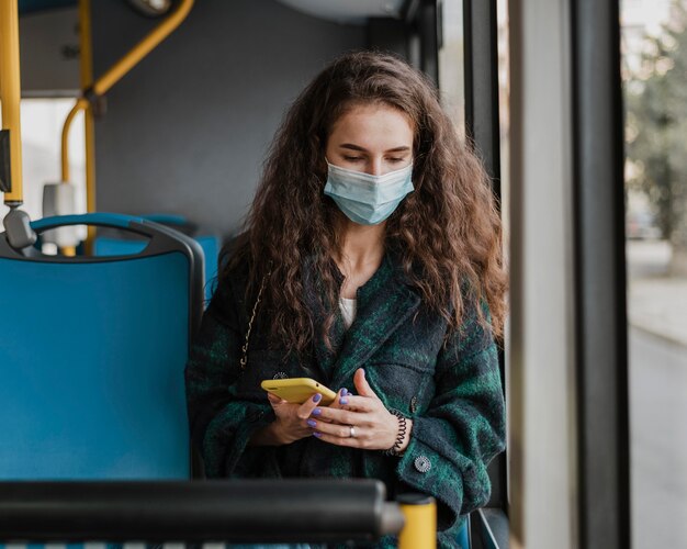 Foto gratuita mujer con cabello rizado vistiendo máscara médica vista frontal