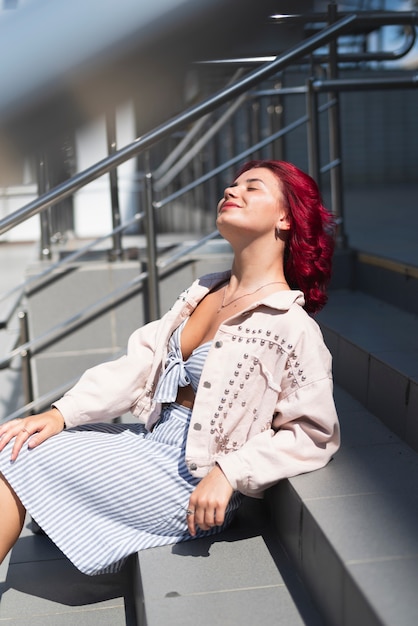 Mujer con cabello rojo sentado en las escaleras