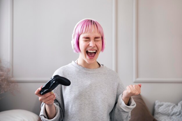 Mujer con cabello rosado jugando a un videojuego