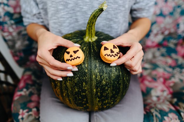 Mujer con una calabaza y dos galletas de halloween