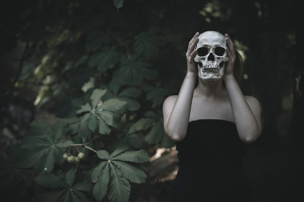 Mujer con calavera en el bosque