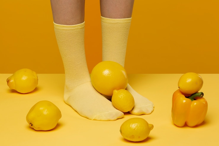 Foto gratuito mujer con calcetines con frutas y verduras a sus pies.